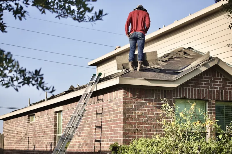 Professional roofer working on a residential roof in Farmbrook